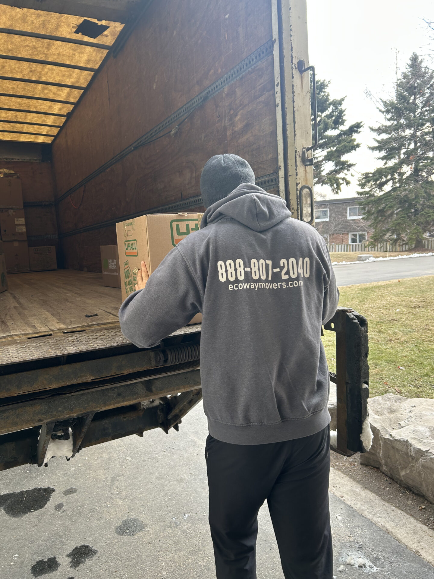 Ecoway Movers Surrey crew professionally organizing and loading stacked boxes into moving truck during Surrey BC residential relocation
