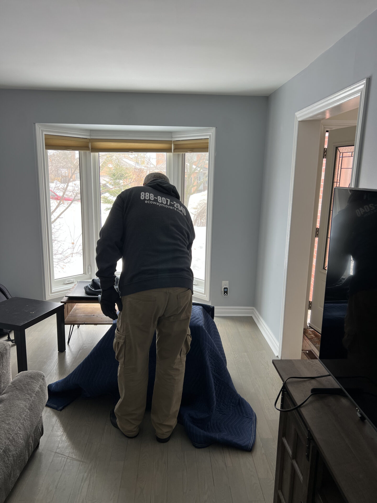 Movers in uniform handling labeled boxes in Oakville condo