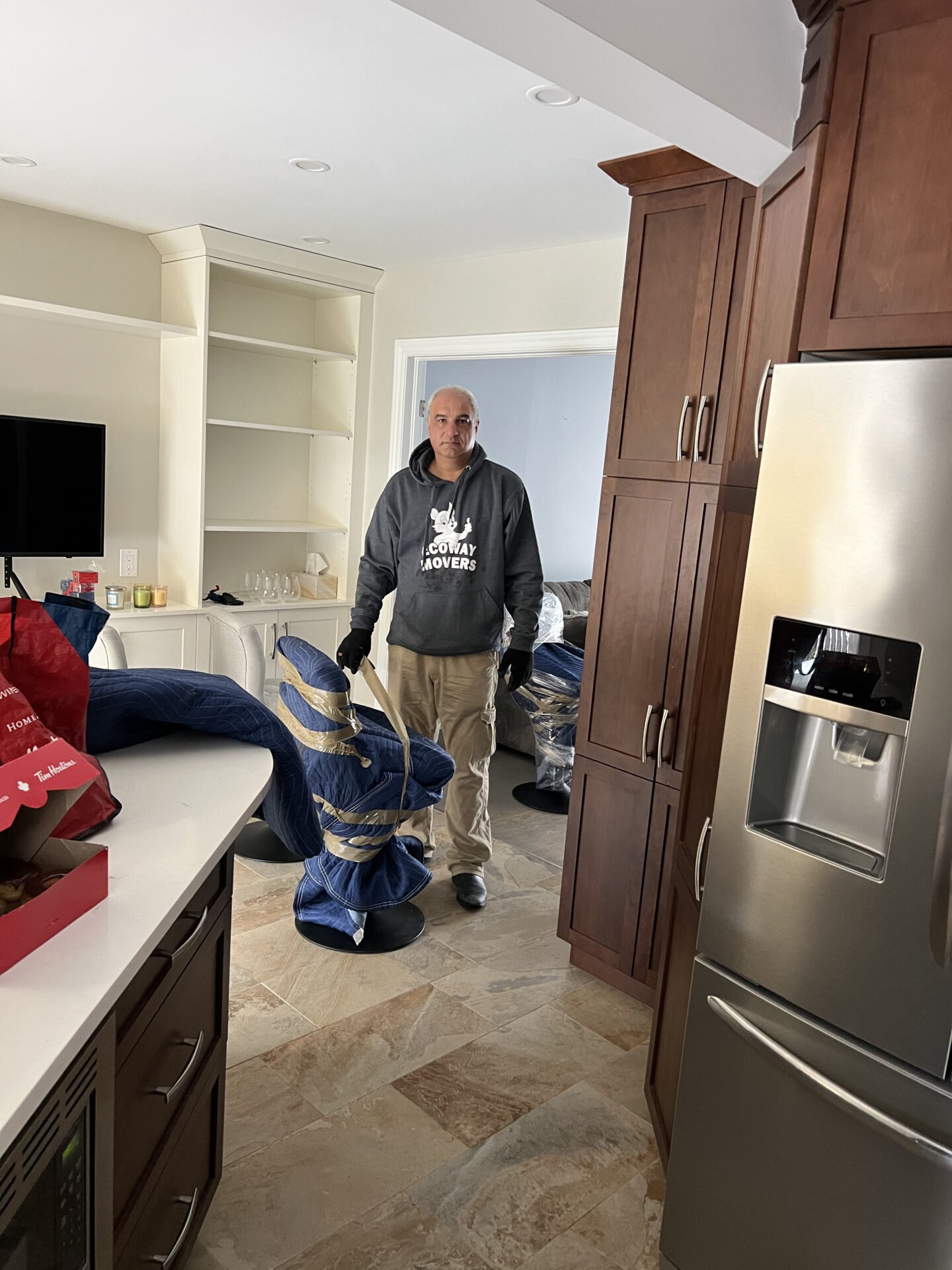 Ecoway Movers Saskatoon SK professional movers wrapping and securing furniture with stretch wrap and moving blankets before loading onto the moving truck