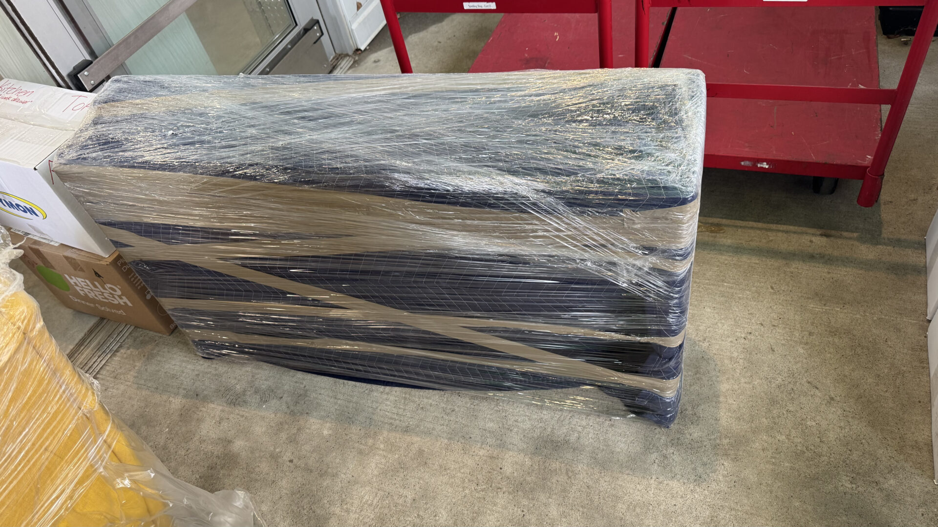 Ecoway Movers Waterloo crew wrapping furniture with protective blankets and stretch wrap before loading into truck during Eastbridge home relocation