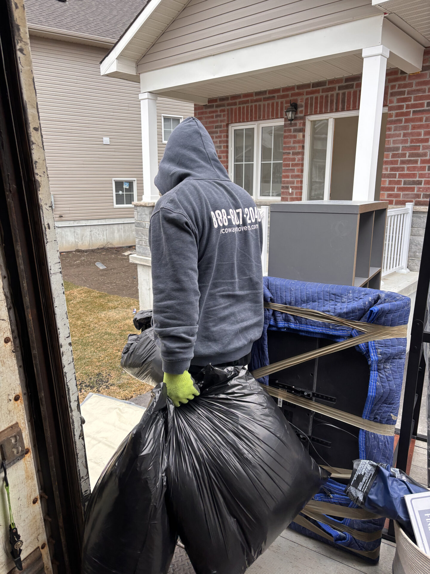 Ecoway Movers Regina SK professional moving crew carefully unloading furniture and boxes at a new home in Harbour Landing Regina with floor protection protocol in place