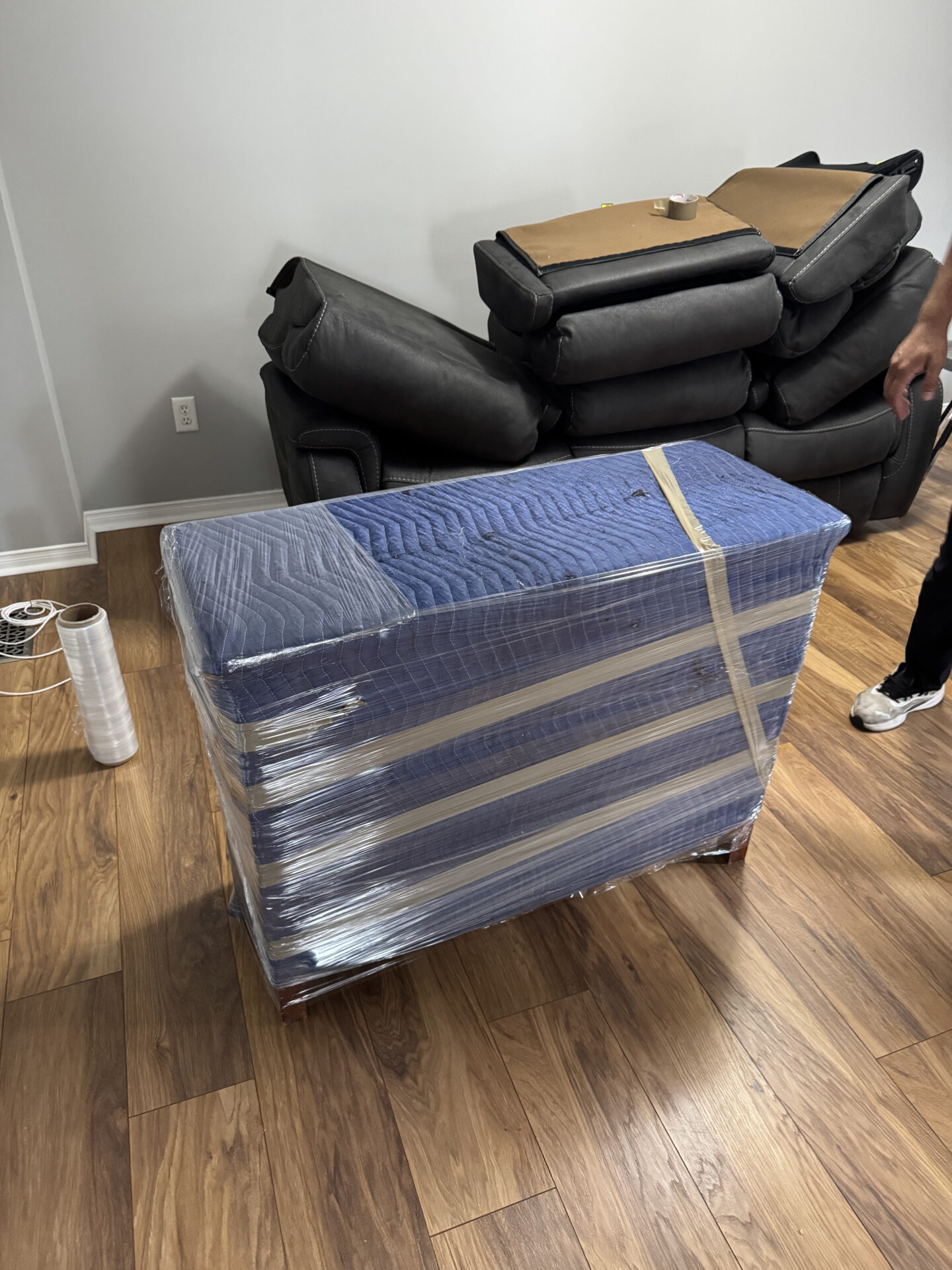 Ecoway Movers wrapping furniture with moving blankets during a Mississauga move