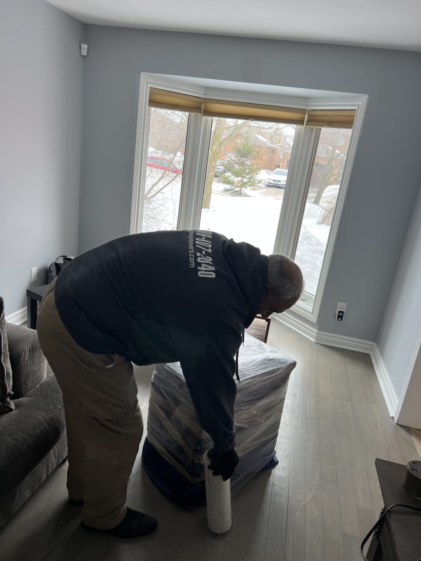Professional movers using piano board and strap system on staircase