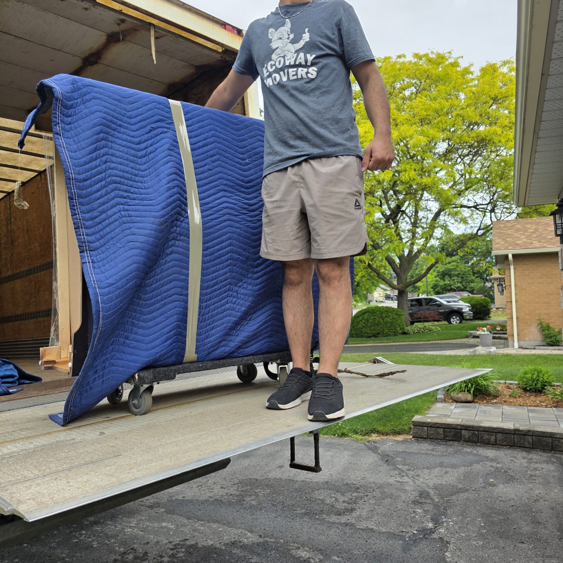 Ecoway Movers heavy equipment specialists moving an upright piano in Waterloo using a professional piano board and rigging straps