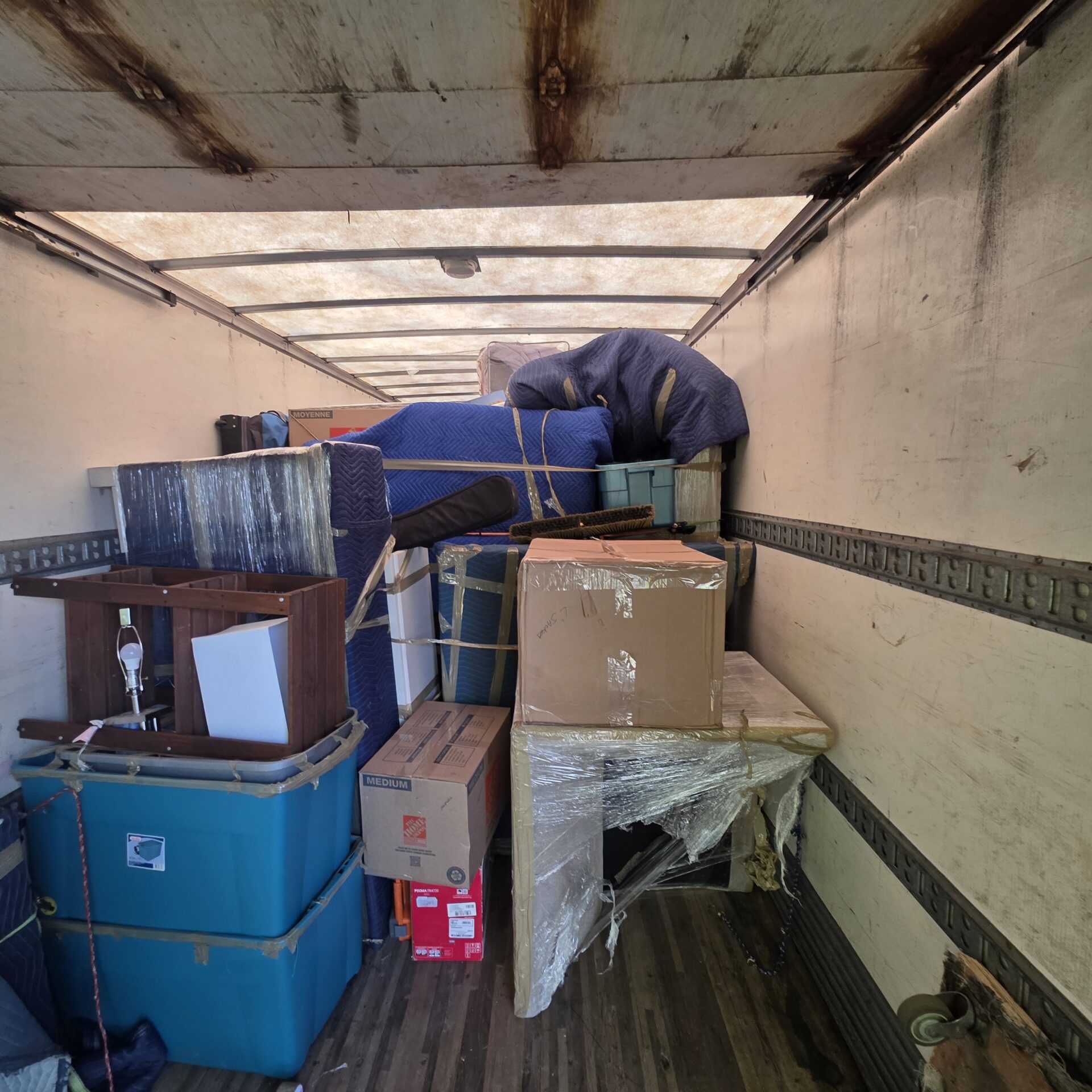 Ecoway Movers professional crew using floor protection and banister wraps in a Calgary SE home during winter