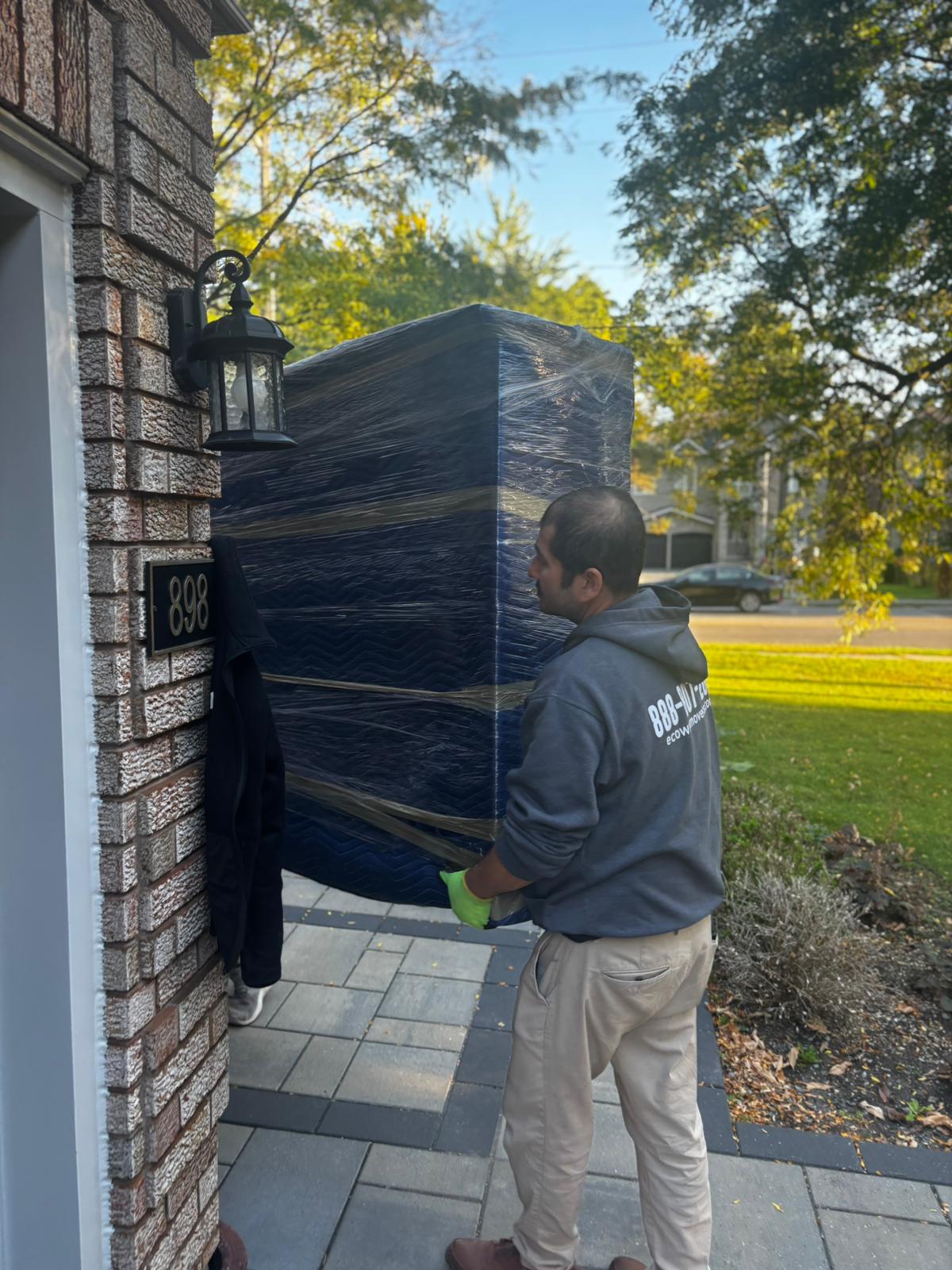 Ecoway Movers executing full-service residential moving and applying thick furniture padding inside a Harrison townhome