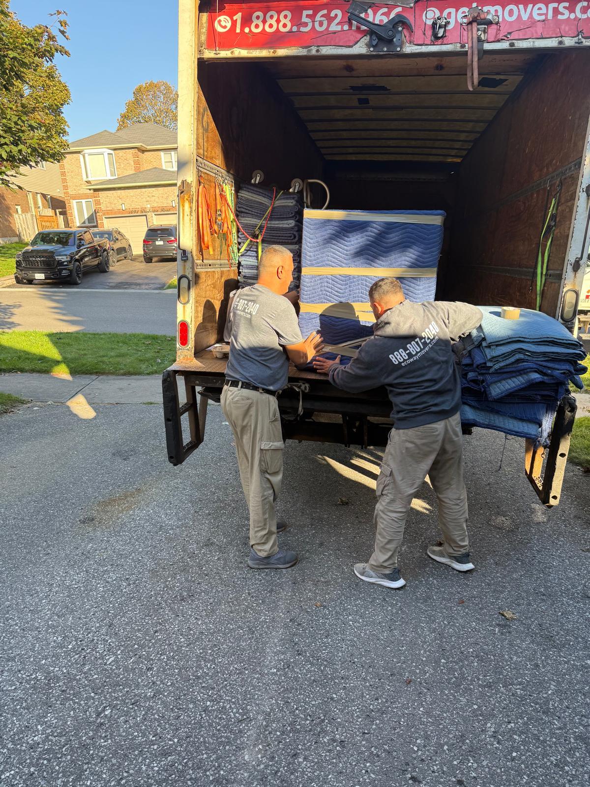 Ecoway Movers crew carefully carrying furniture during a residential moving service