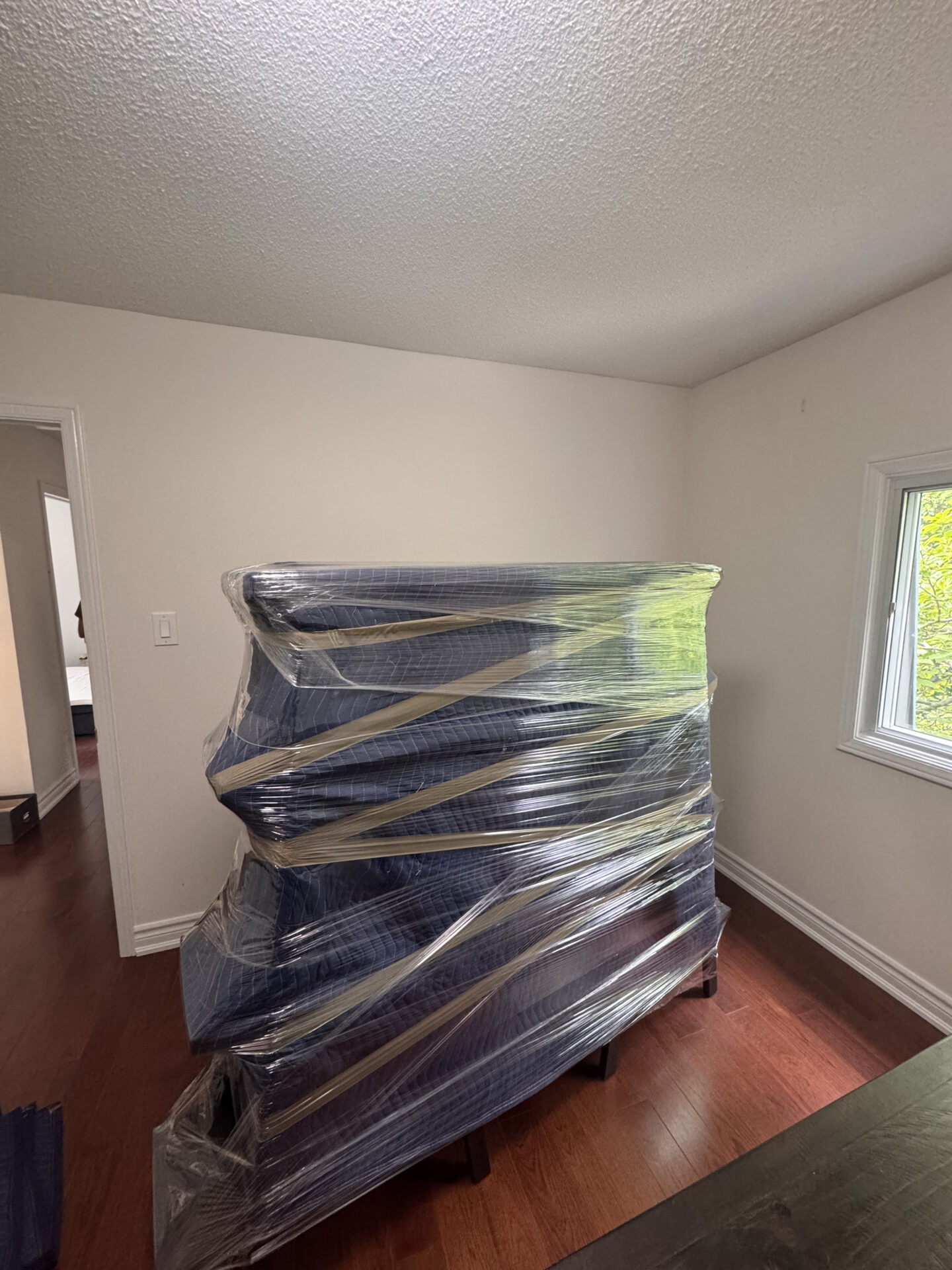 Ecoway Movers Chilliwack team wrapping furniture with professional blankets and plastic wrap during a local move in Chilliwack Fraser Valley
